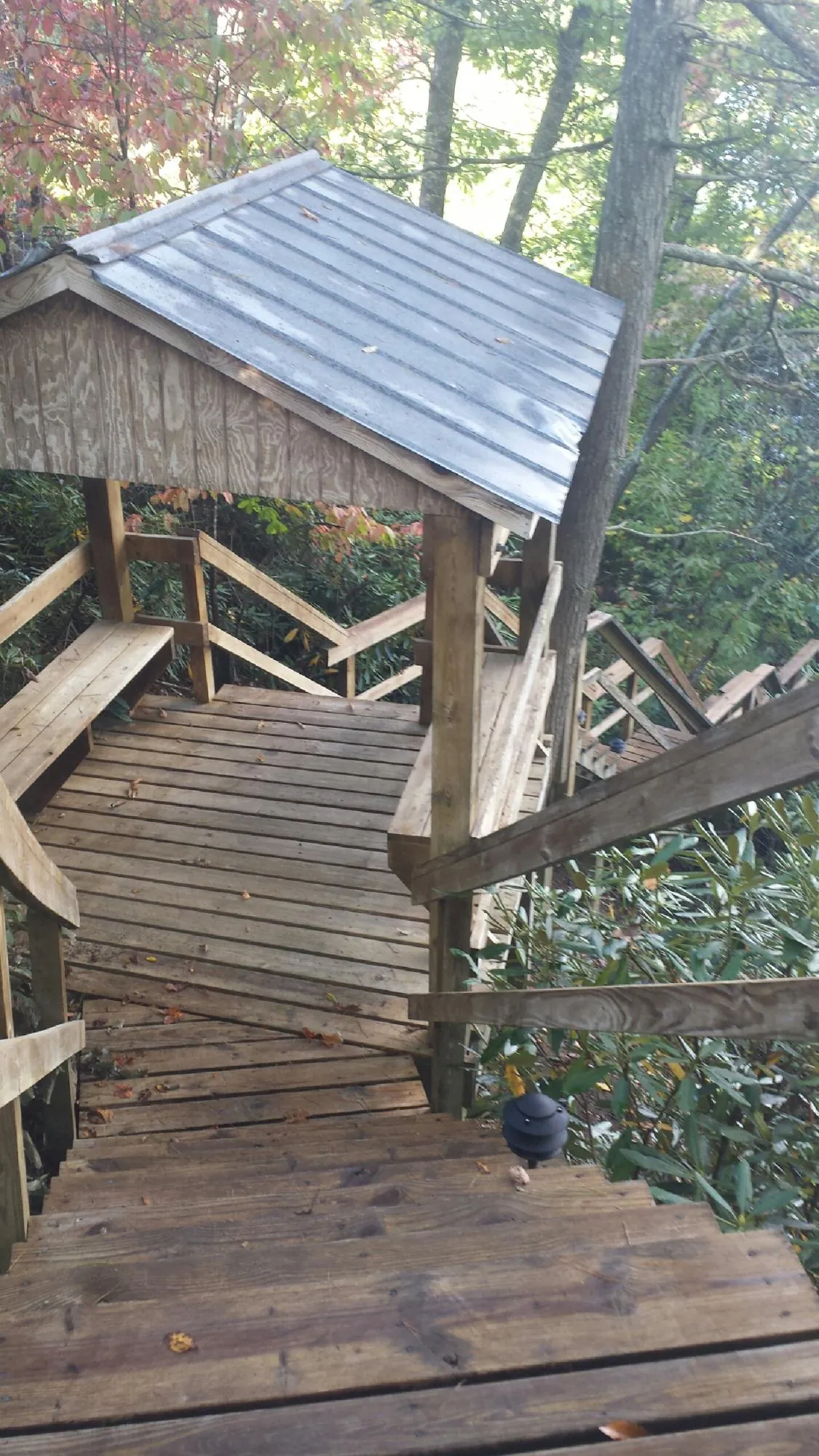 Metal roofed shelter over wooden steps on a wooded walkway — Skylight Repair & Installation work by our crew in Stanley